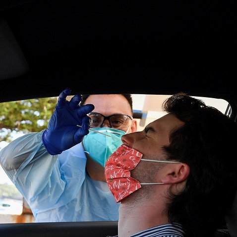 Angus Horton receives a COVID-19 test at the St Vincents Hospital drive-through testing clinic at Bondi Beach in Sydney, Wednesday, December 15, 2021. NSW will open up to the unvaccinated just as COVID-19 cases start to spiral, and the highly transmissibl