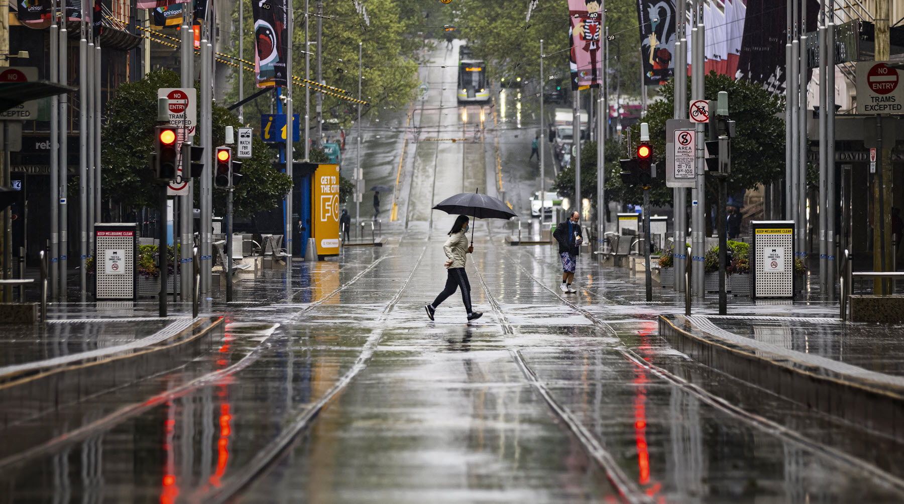 People are seen crossing Bourke Street in Melbourne.