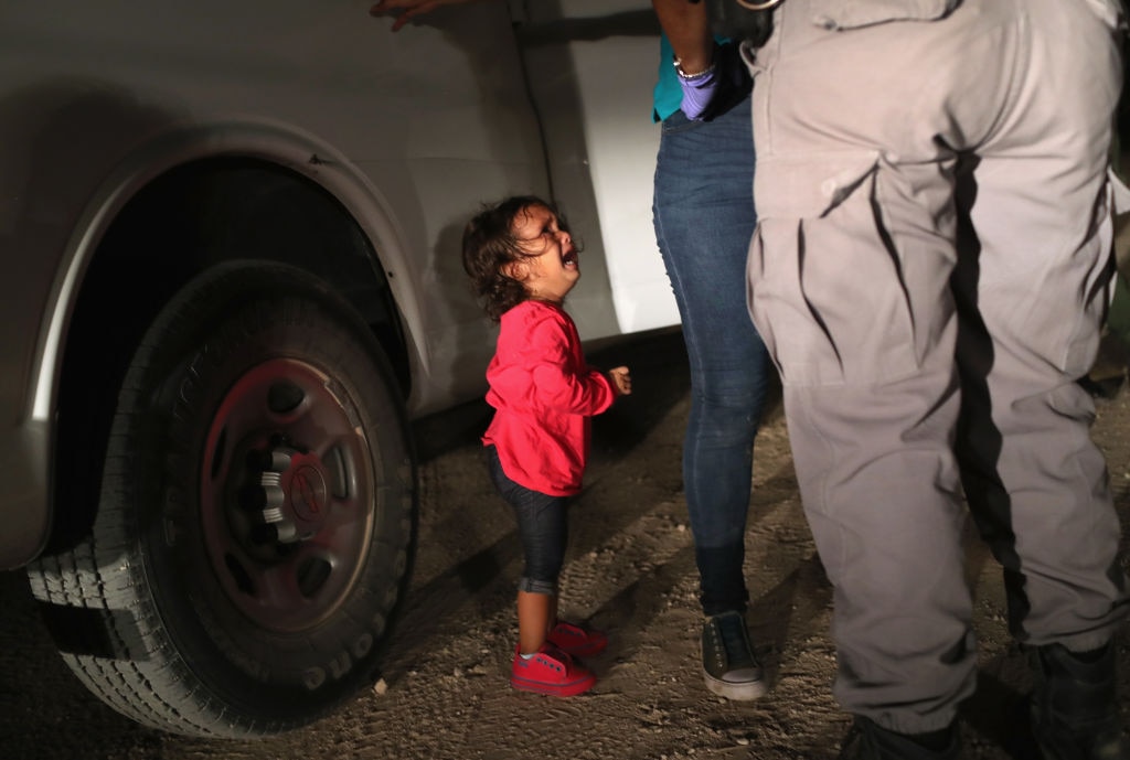 A two-year-old Honduran asylum seeker cries as her mother is searched and detained near the US.-Mexico border on June 12, 2018 in McAllen, Texas.