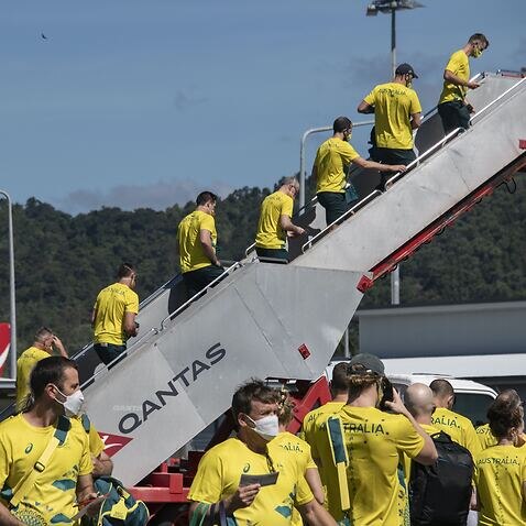Athletes and officials of Australia's Olympic team wearing PPE face masks depart on a chartered flight from Cairns bound for the Tokyo Olympics at Cairns International Airport.
