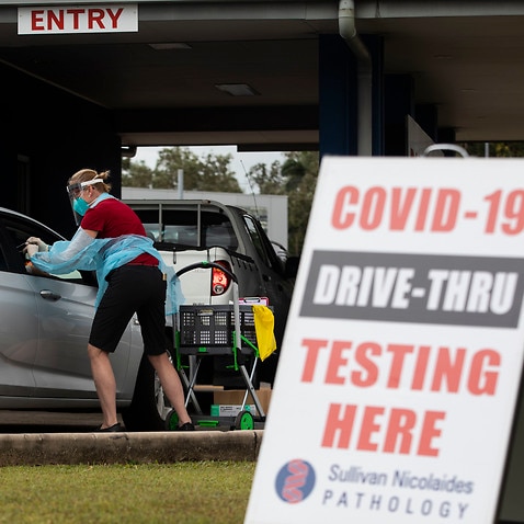 A health worker conducts a COVID-19 test at a drive through facility at Woree in Cairns, Sunday, August 8, 2021.