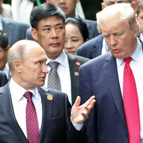 Donald Trump and Vladimir Putin talk during a photo session at the APEC summit in Vietnam.