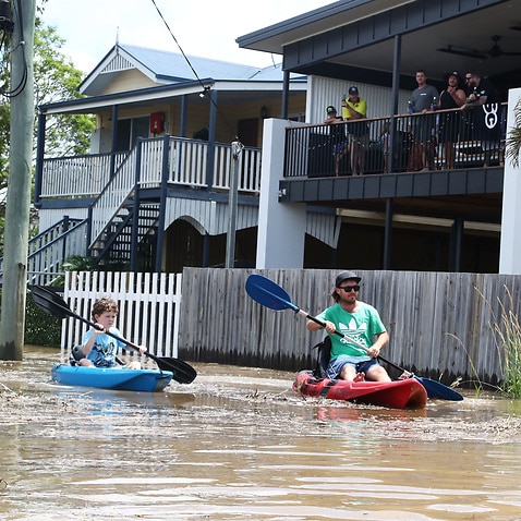 Residents of Tumbulgum paddle their kayaks down a street in Northern NSW,  Tuesday, 15 December, 2020. 
