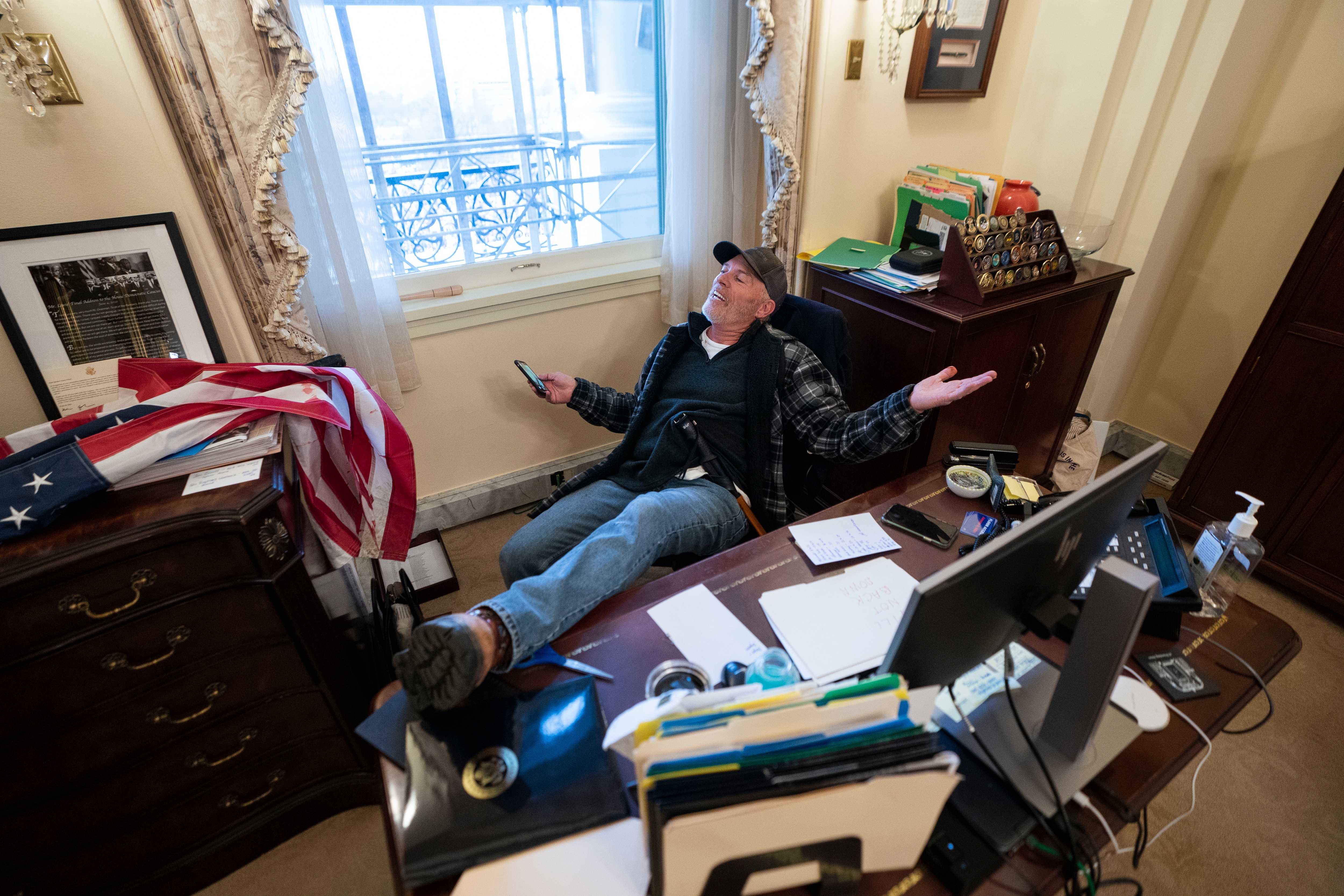 أحد مؤيدي ترامب يجلس على مكتب رئيسة مجلس النواب الأمريكي نانسي بيلوسي