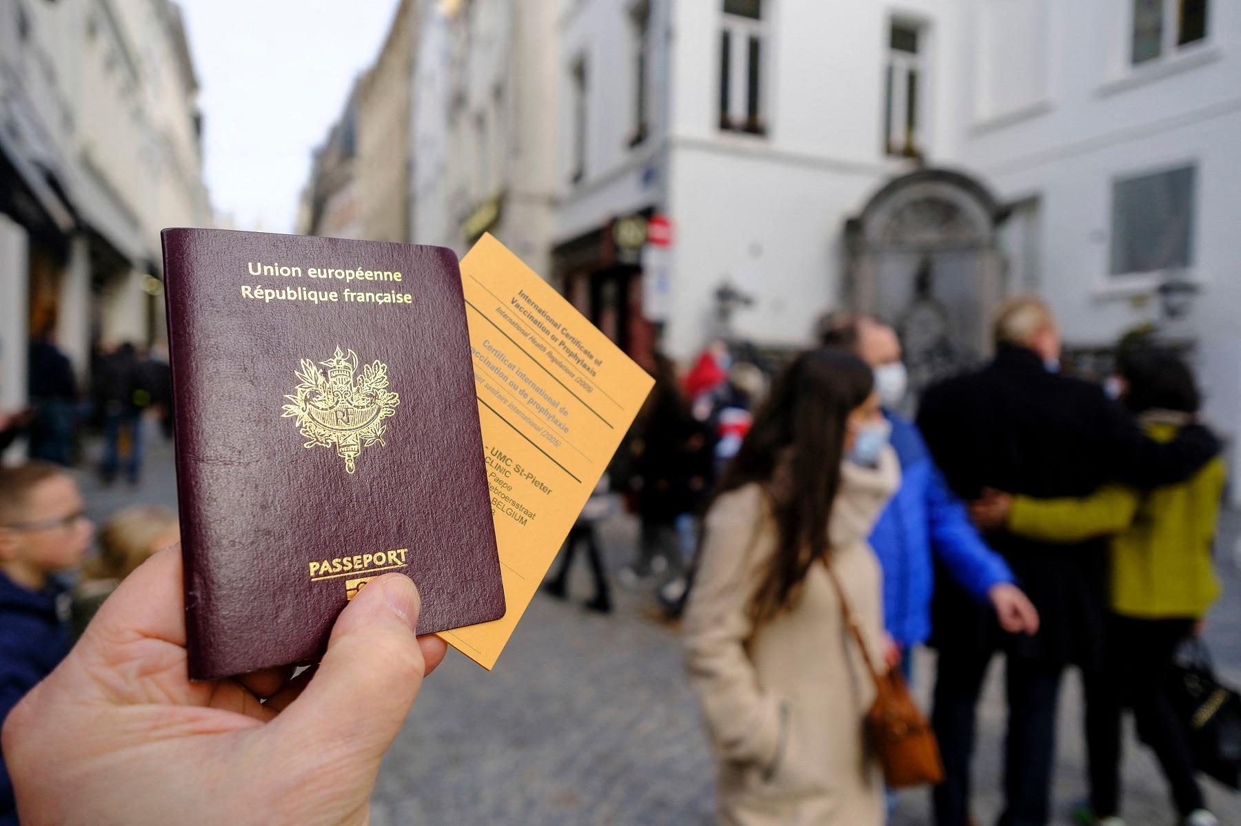 A French passeport and an International Certificate of Vaccination or Prophylaxis are seen in an illstration pictures on February 19, 2021 in Brussels, Belgium. Back is the famous statue of the Manneken-Pis. - Photo by Monasse T/ANDBZ/ABACAPRESS.COM.