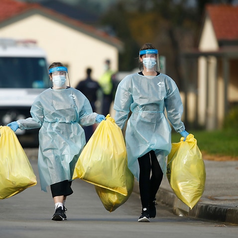 Medical staff with bags of clinical waste is seen at St. Basil's Homes for the Aged in Victoria in Fawkner, Melbourne, Monday, 27 July, 2020. 