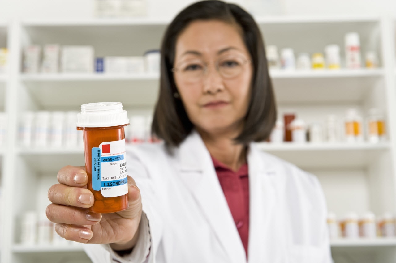 A file image of a pharmacist holding prescription medication. 