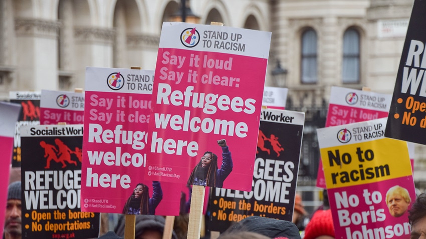 Protesters hold 'Refugees Welcome' placards during a demonstration outside Downing Street, London.