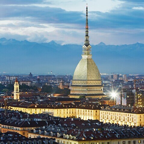 Elevated view of the 'Mole Antonelliana', the cityscape of Turin (Torino) and the Alps at dusk