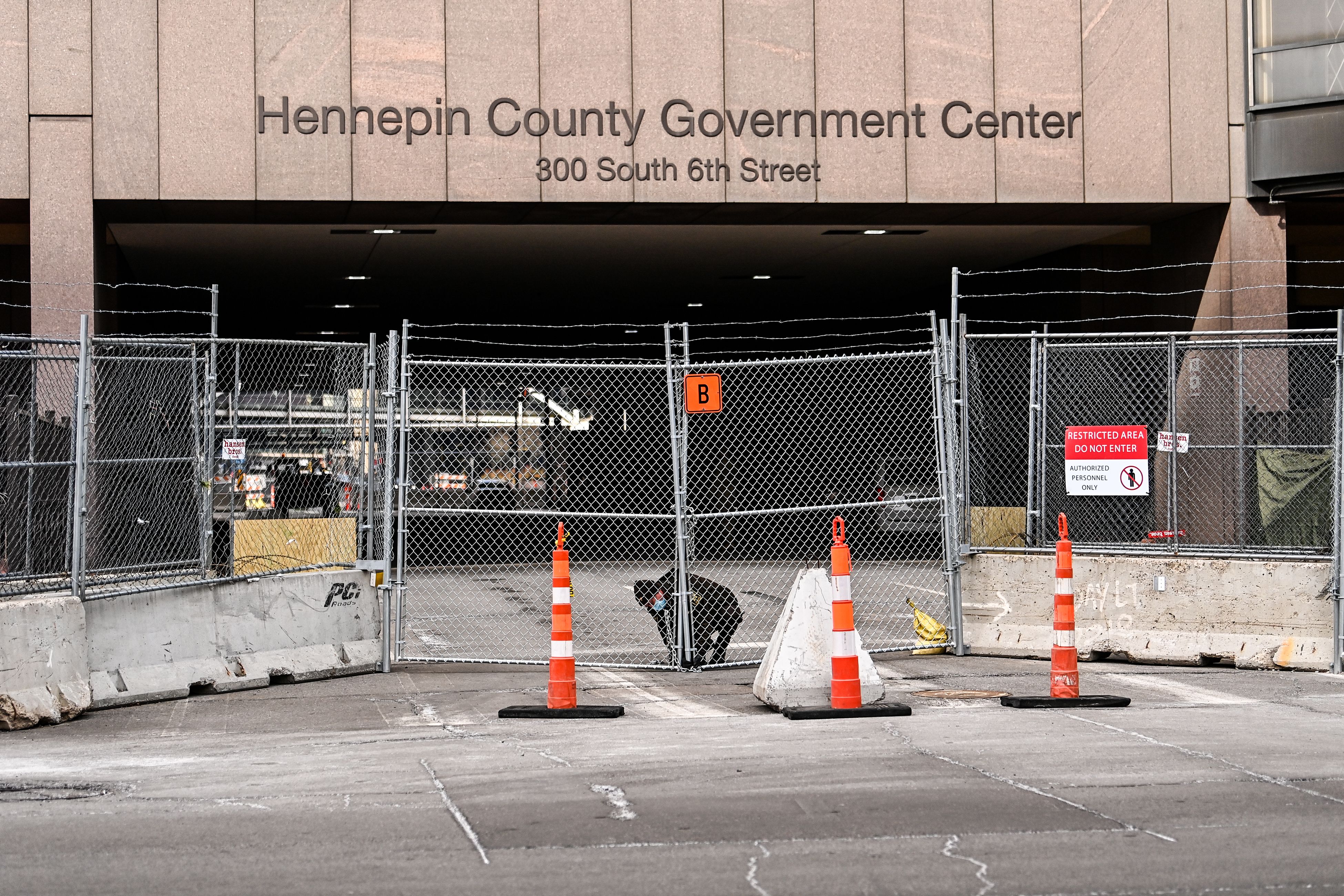 Law enforcement officers lock the barricades in front of the Hennepin County Government Center on Sunday.