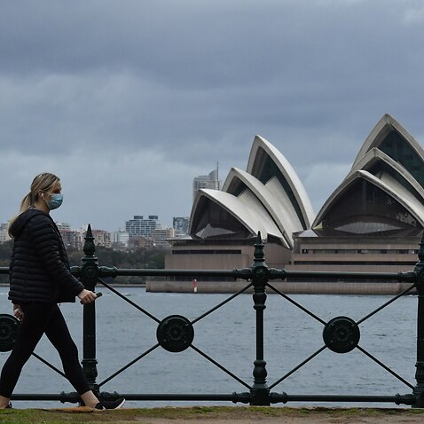 A pedestrian walks past the Sydney Opera House in Sydney.