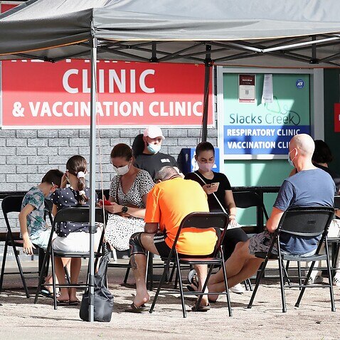 People wait outside a COVID testing clinic South of Brisbane, Wednesday, January 5, 2022. (AAP Image/Jono Searle) NO ARCHIVING