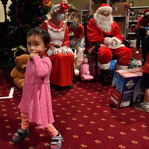 The children of needy families are give Christmas presents by Santa Clause at the Reverend Bill Crews Foundation at Ashfield in Sydney.