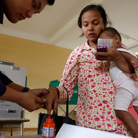 Local has her finger in an ink bottle after voting at a polling station in Phnom Penh, Cambodia