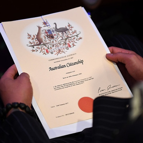 An Australian citizenship recipient holds his certificate during a citizenship ceremony on Australia Day.