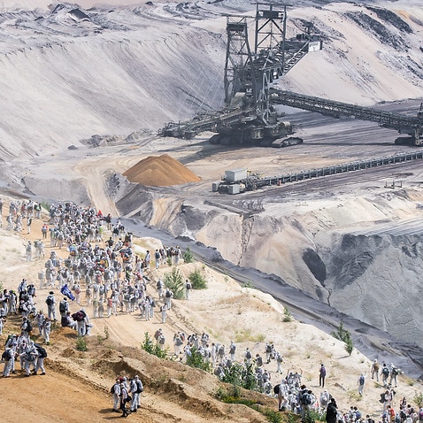 Climate activists broke through a police line and ran across a field into the mine as part of a protest against coal mining.
