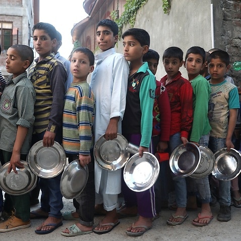 صف کودکان یتیم کشمیری برای دریافت غذا