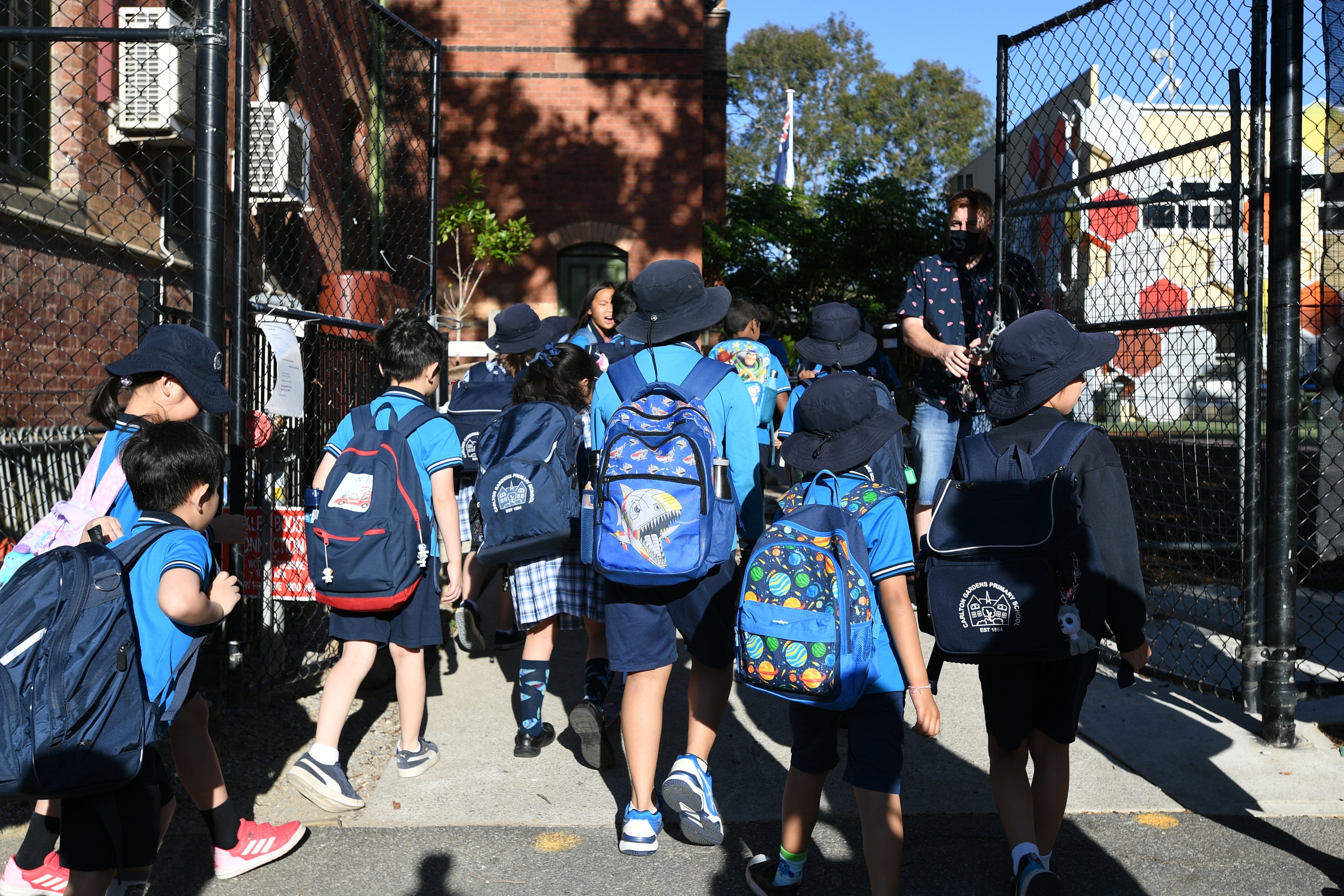 Students arrive to Carlton Gardens Primary school in Melbourne, Thursday, February 18, 2021. Victoria has recorded no new locally acquired coronavirus cases as life returns to COVID-normal after the state's five-day "circuit breaker" lockdown. (AAP Image/