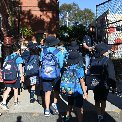 Students arrive to Carlton Gardens Primary school in Melbourne, Thursday, February 18, 2021. Victoria has recorded no new locally acquired coronavirus cases as life returns to COVID-normal after the state's five-day 