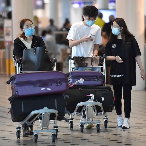 People wearing protective face masks at Brisbane International Airport.