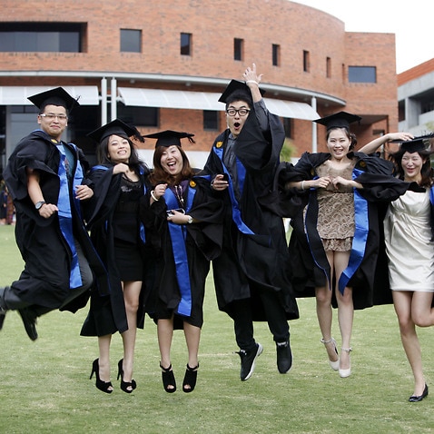 Chinese students studying at Curtin University in Perth pose during a graduation photo shoot (AAP).