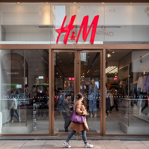 A woman walks by an H&M store in Shanghai, China on Wednesday, 24 March.
