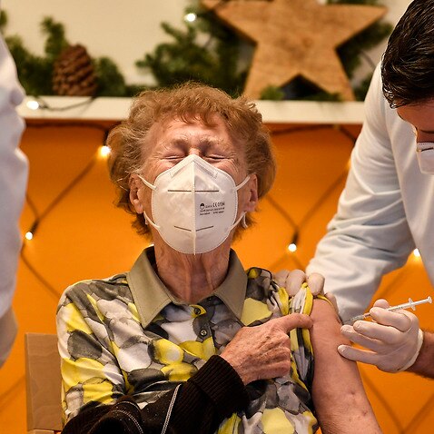 A resident of a nursing home gets an injection of the COVID-19 vaccine in Cologne, Germany.