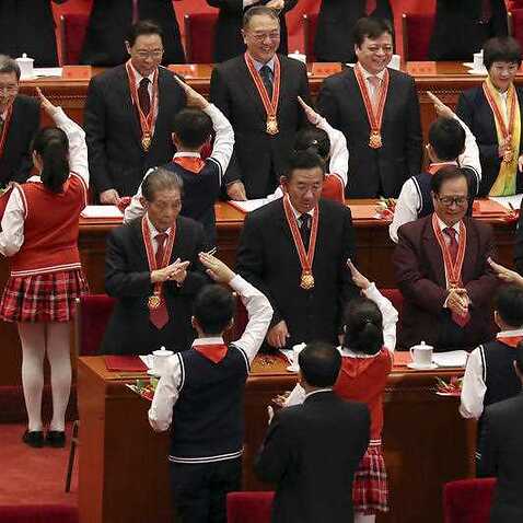 Children salute medallion recipients during the conference to commemorate the 40th anniversary of China's Reform and Opening Up policy.