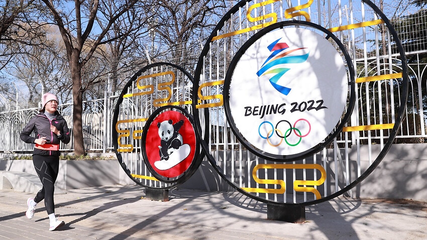 A jogger runs by a street decoration for the Beijing 2022 Winter Olympics at National Olympic Sports Center on 24 November, 2021 in Beijing, China.