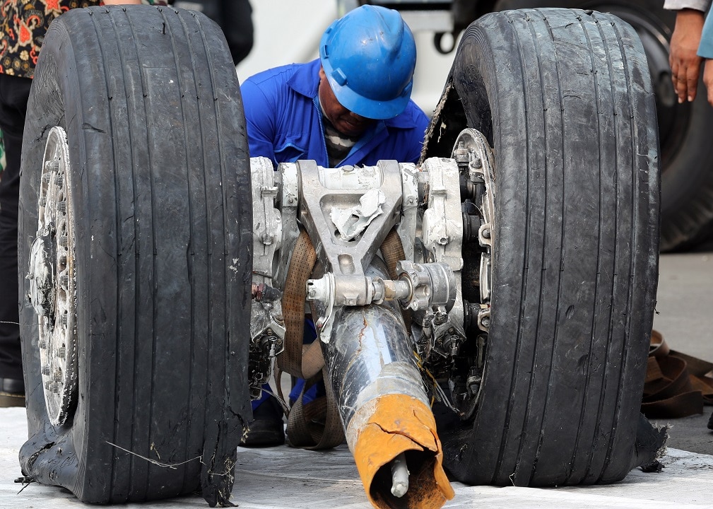 Un responsable indonésien inspecte une roue récupérée du vol JT610 du Lion Air s’est écrasé.