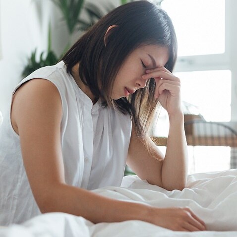 Young Woman Suffering Headache In Bed