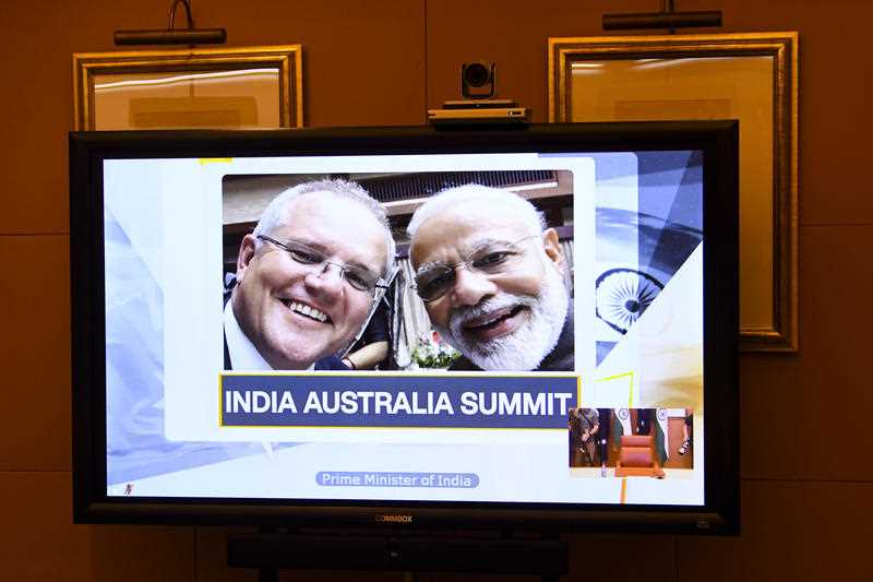 A picture of Australian Prime Minister Scott Morrison (left) and Indian Prime Minister Narendra Modi is displayed on a conference screen