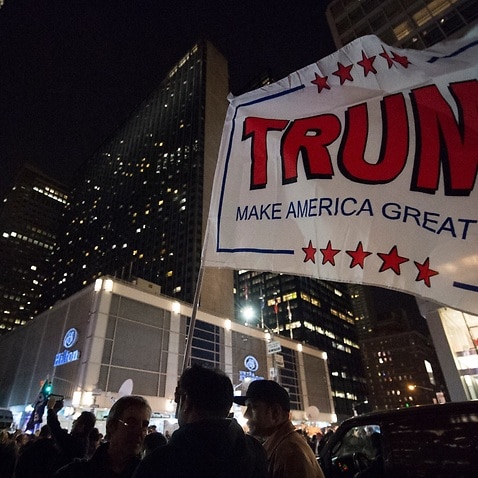 Donald Trump supporters waving a large Trump flag outside Hilton Midtown in Manhattan, 
