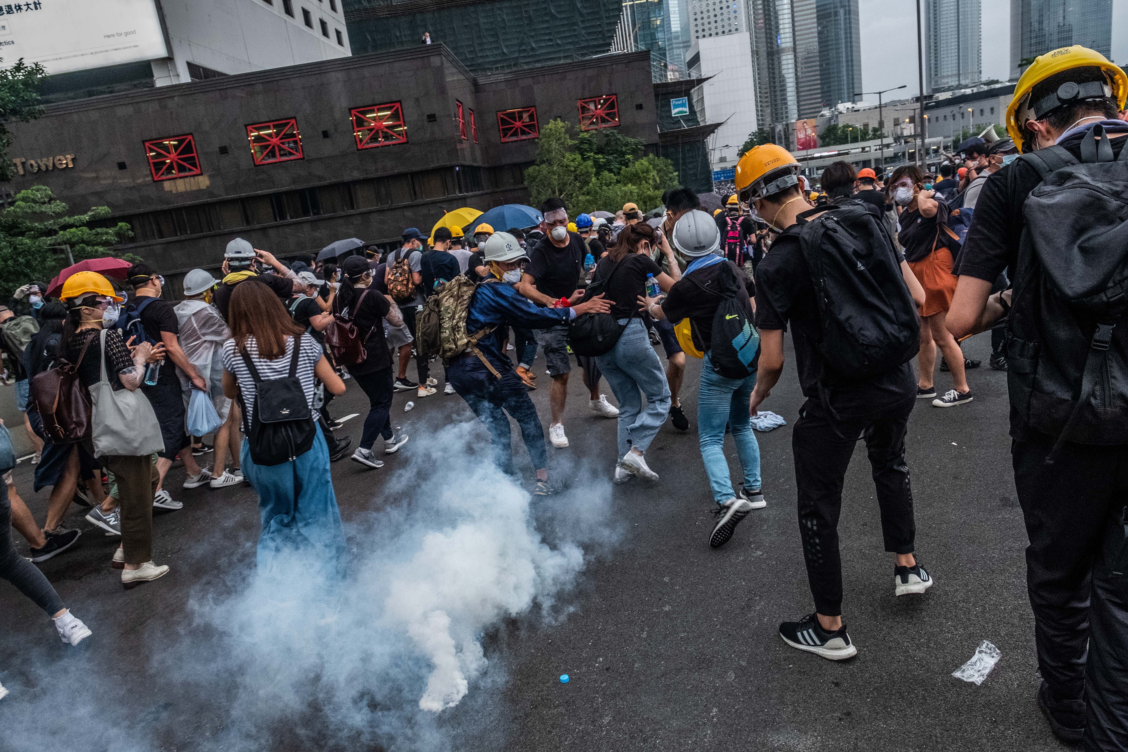 Protesters flee from a tear gas canister outside the Legislative Council in Hong Kong on Wednesday, June 12, 2019. Protesters flee from a tear gas canister outside the Legislative Council in Hong Kong.