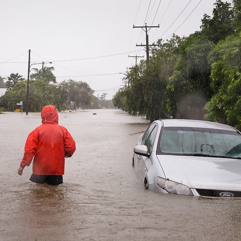A man walks through flood water in Rosslea, Townsville, Saturday, 2 February, 2019.