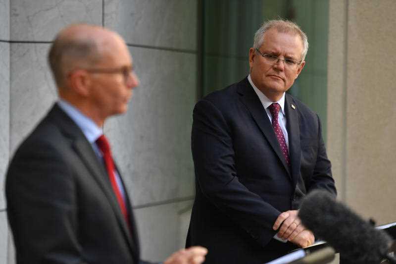 Prime Minister Scott Morrison (R) listens to Chief Medical Officer Paul Kelly (L)