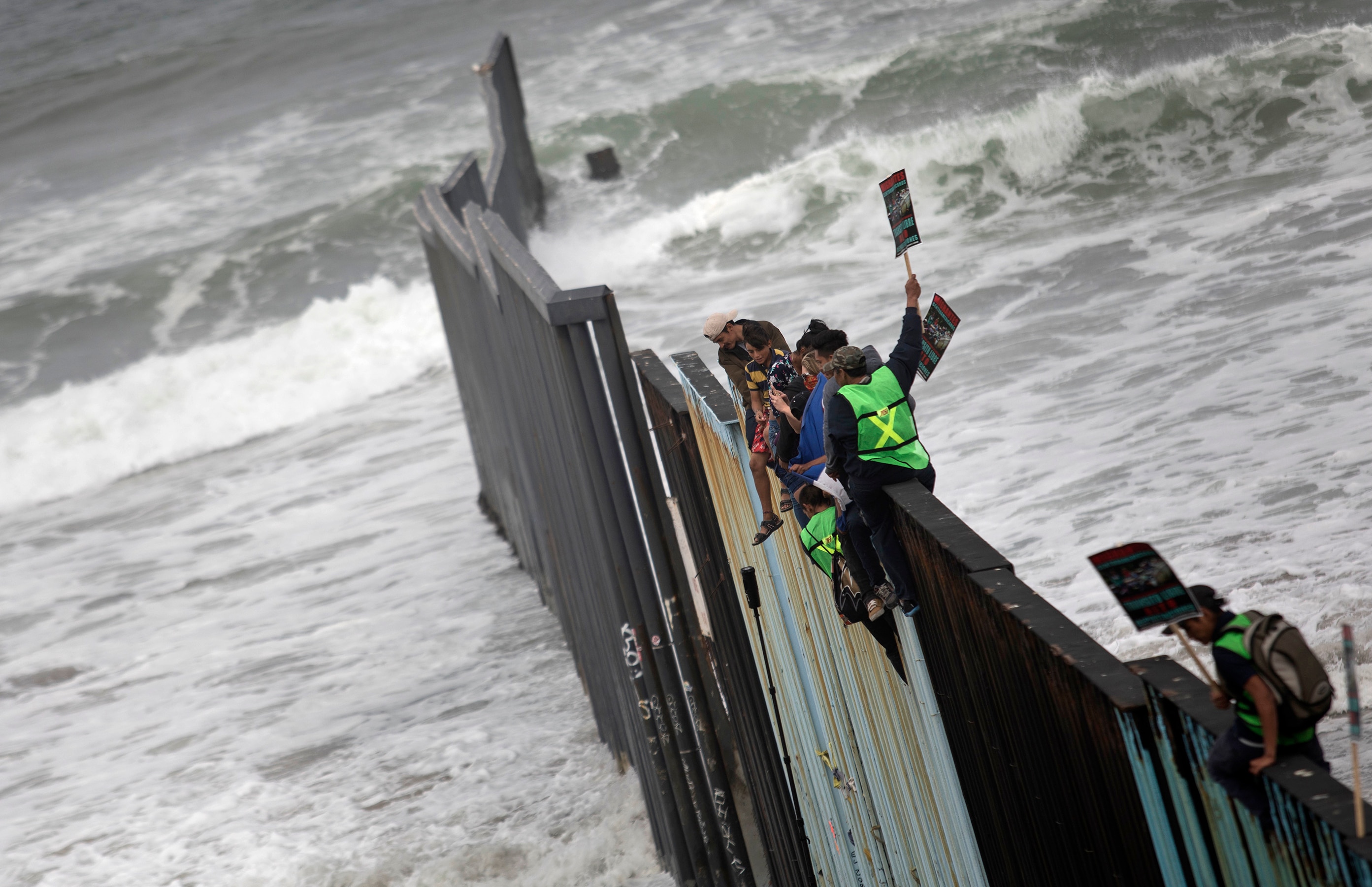 'Caravan migrants' scale US-Mexico border wall during protest | SBS News