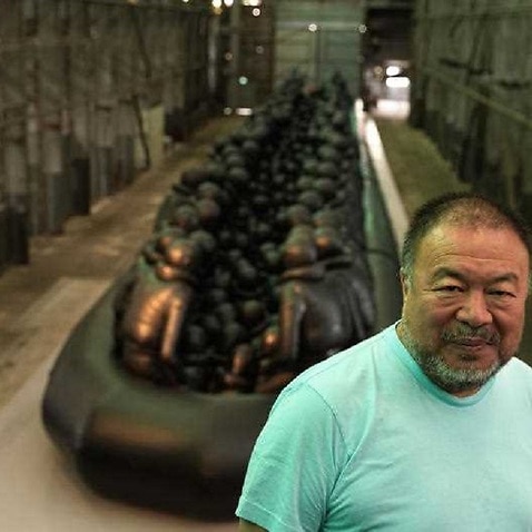Ai Weiwei poses in front of his installation Law of the Journey in Sydney 