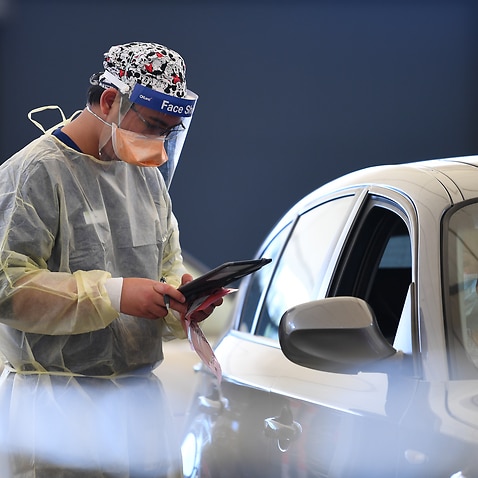 Helathcare worker Allen Pelisco is seen working at a drive-through Covid19 testing facility in Melbourne