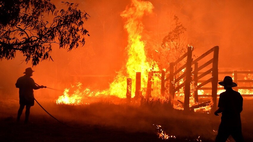 Residents and RFS crews defend a property from a bushfire in northern NSW. 