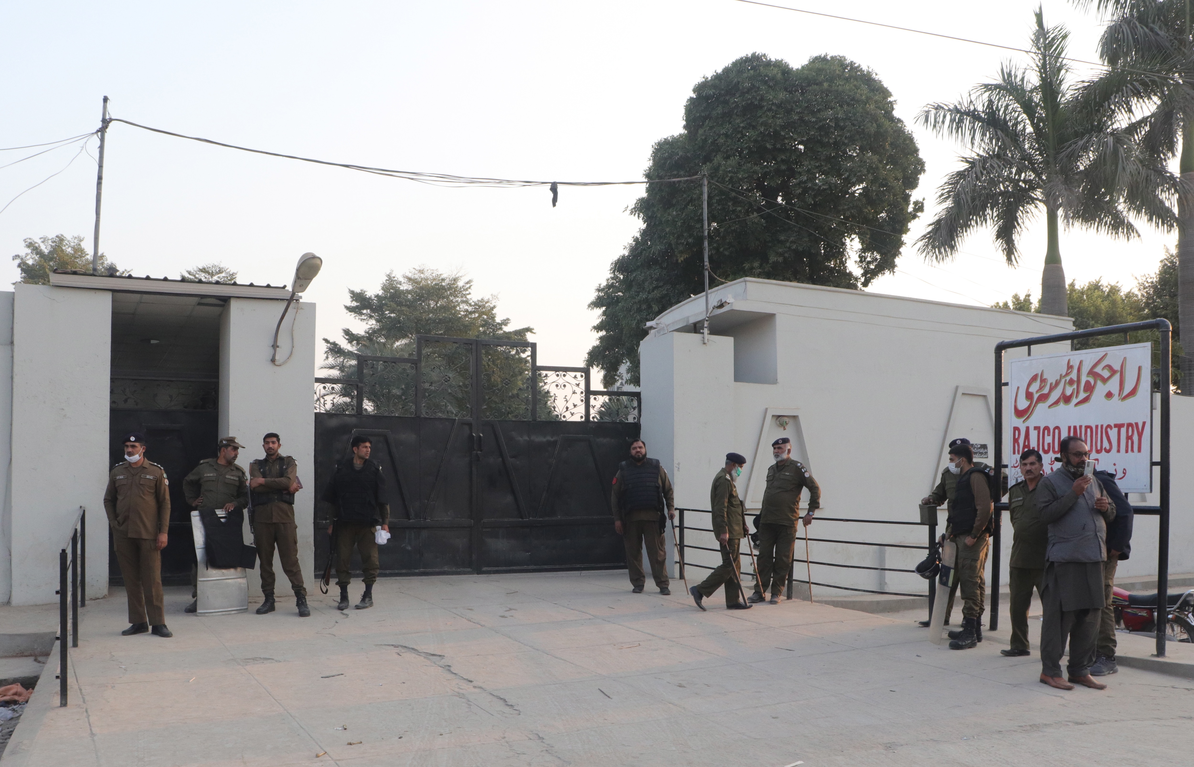 Pakistani security officials stand guard outside the factory where the lynching occurred