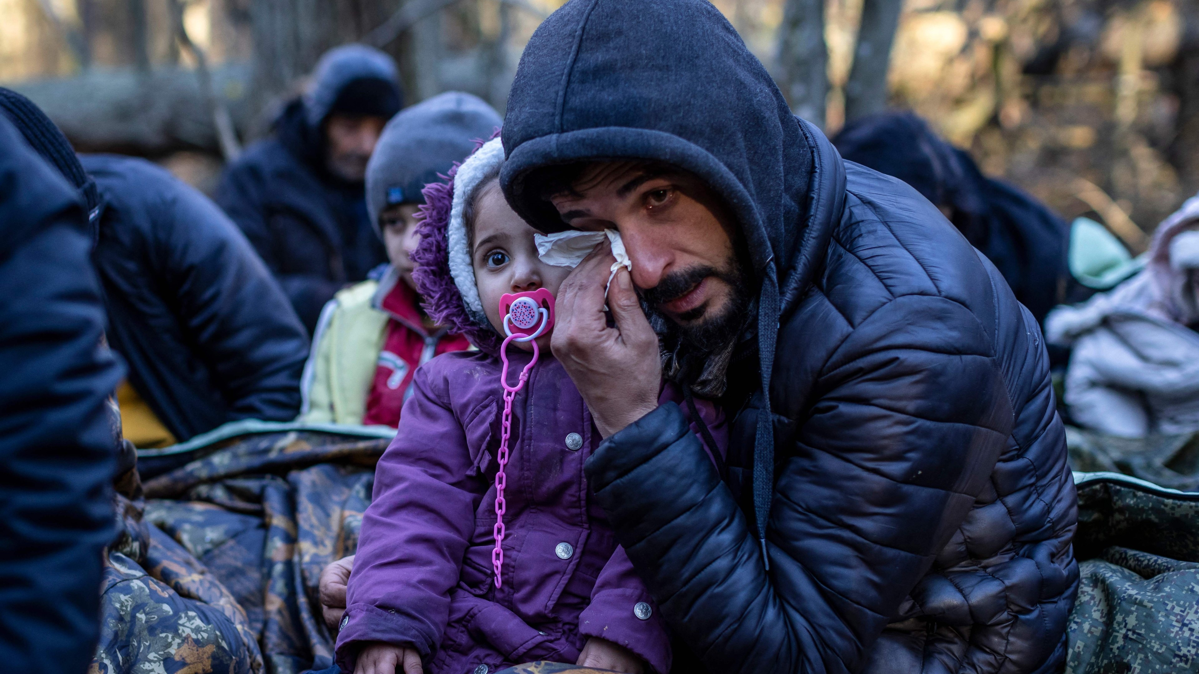Migrants wait at the Poland-Belarus border. 