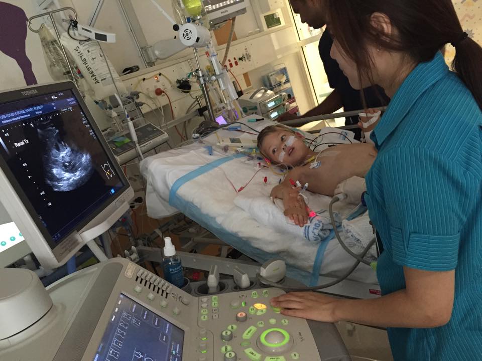 Image of a child receiving ultrasonic scan in hospital bed