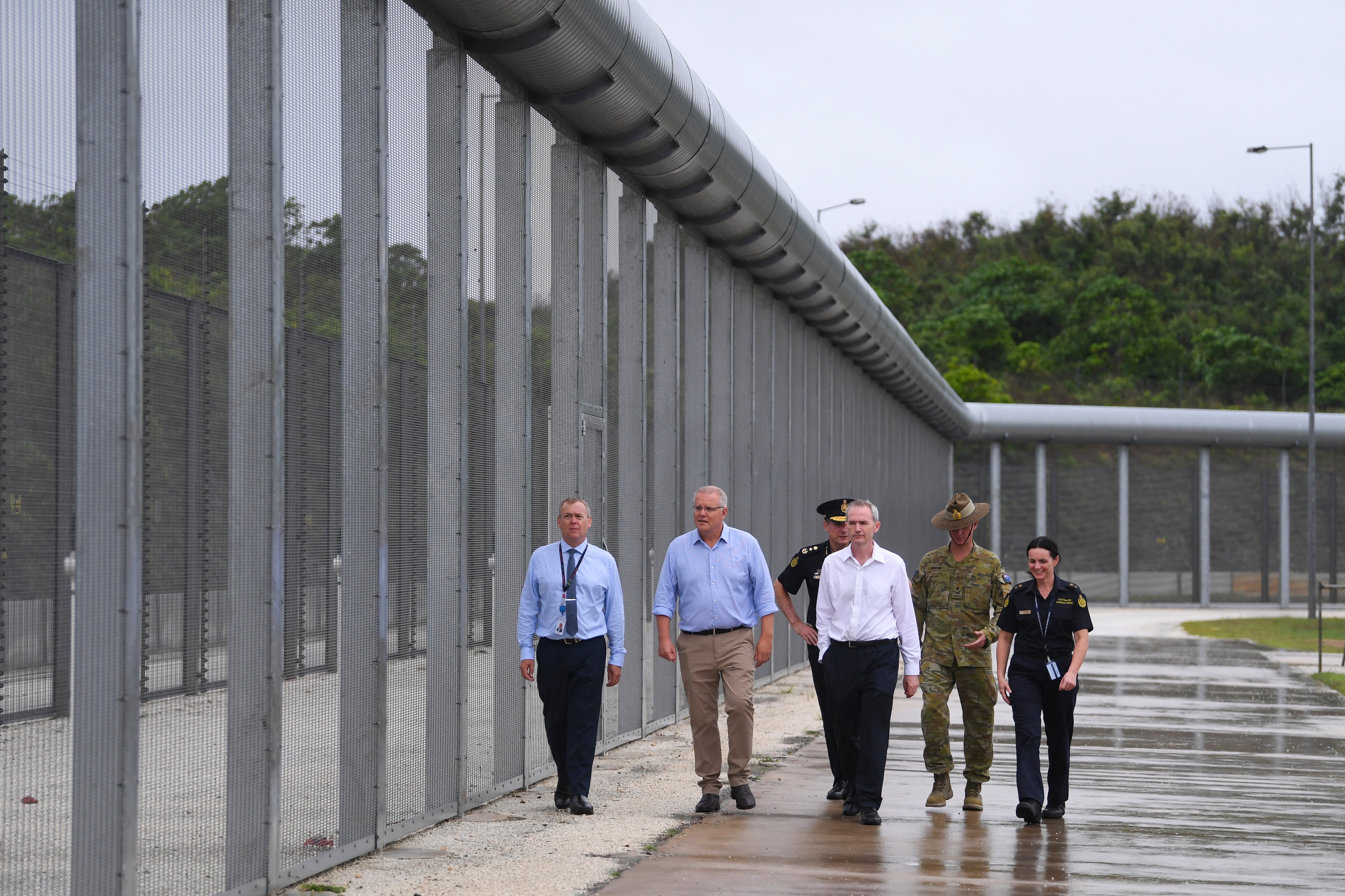 Australian Prime Minister Scott Morrison is seen near the perimeter fence as he tours North West Point Detention Centre on Christmas Island