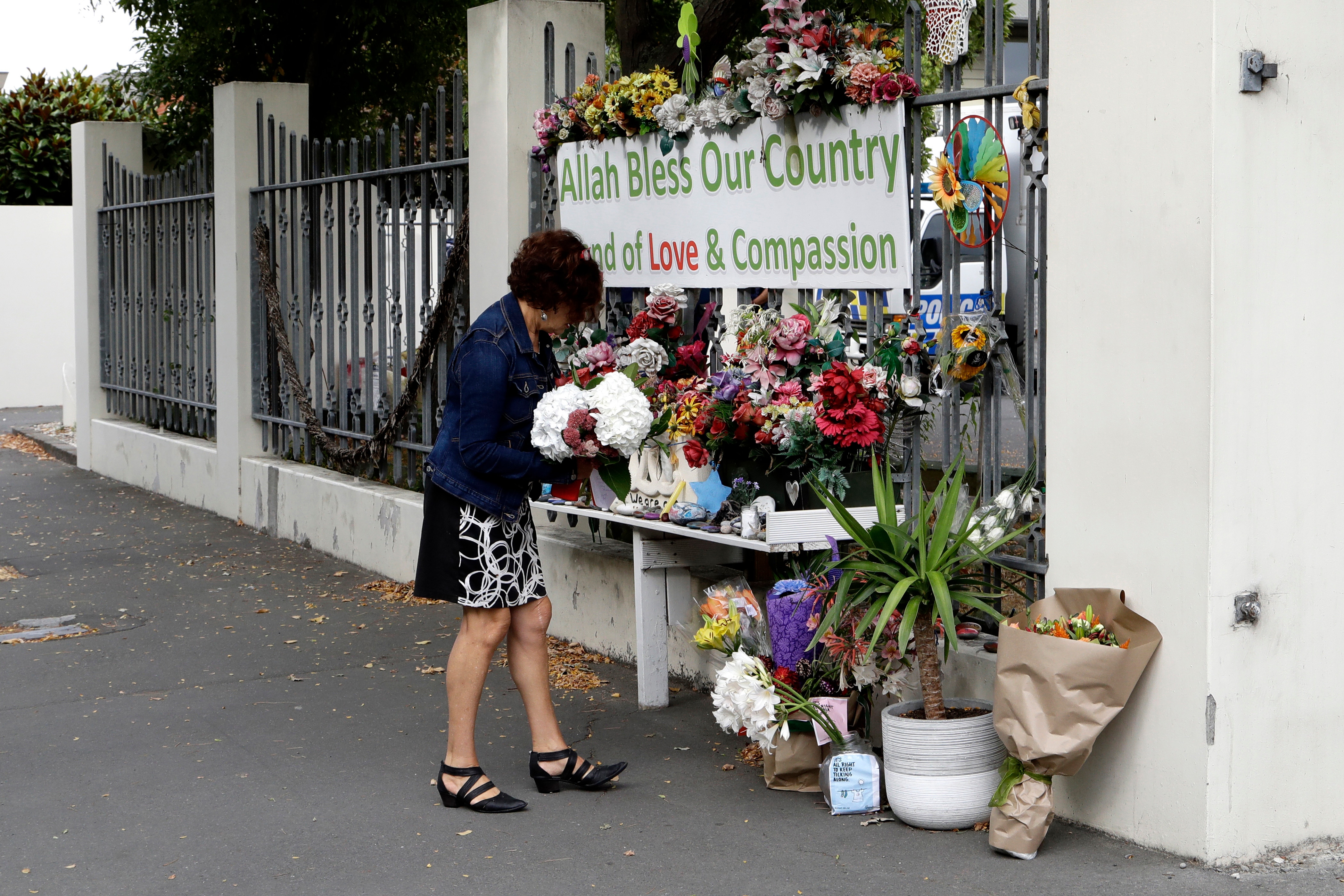 A woman prepares to place flowers at the Al Noor mosque in Christchurch, New Zealand, Friday, March 13, 2020. A woman prepares to place flowers at the Al Noor mosque in Christchurch