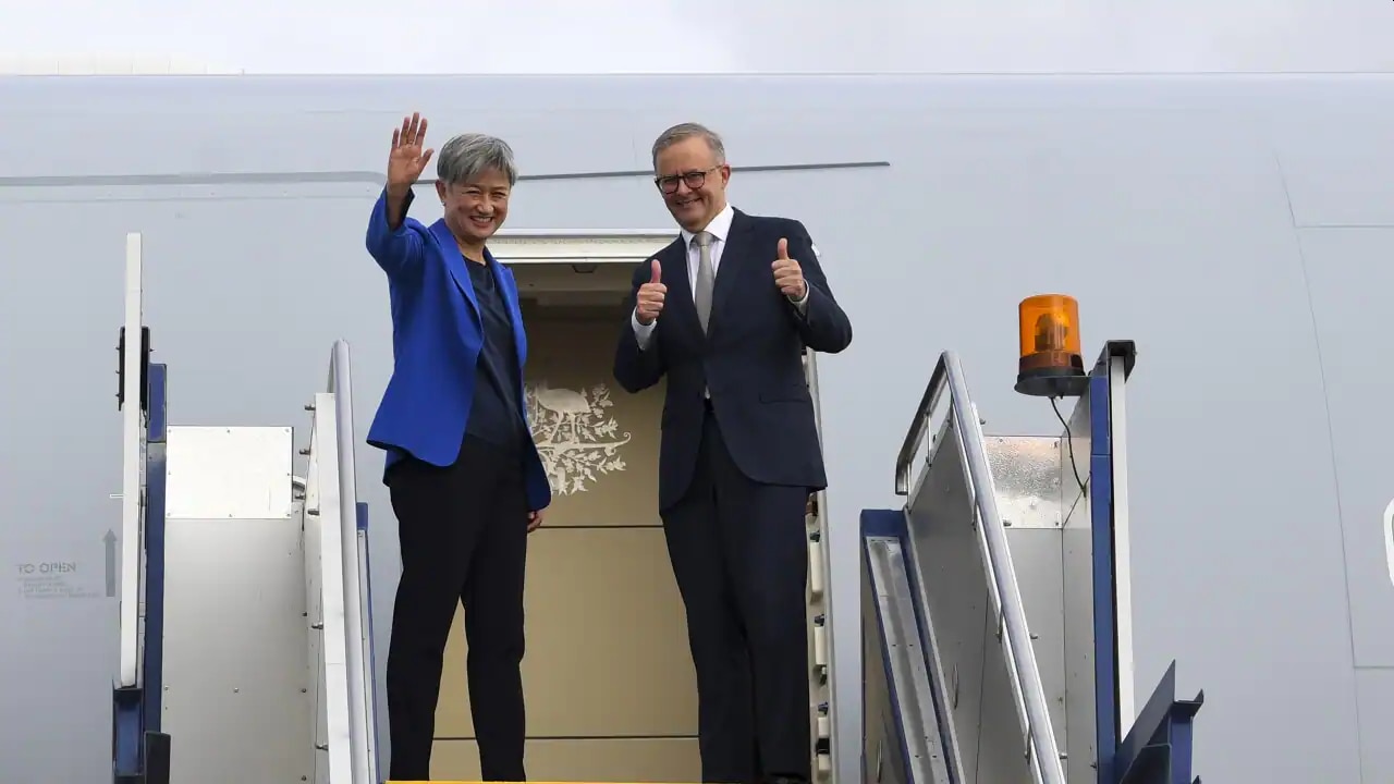 Australian Prime Minister Anthony Albanese and Foreign Minister Penny Wong wave as they board the plane to Japan to attend the QUAD leaders meeting in Tokyo, Canberra, Monday, 23 May, 2022.