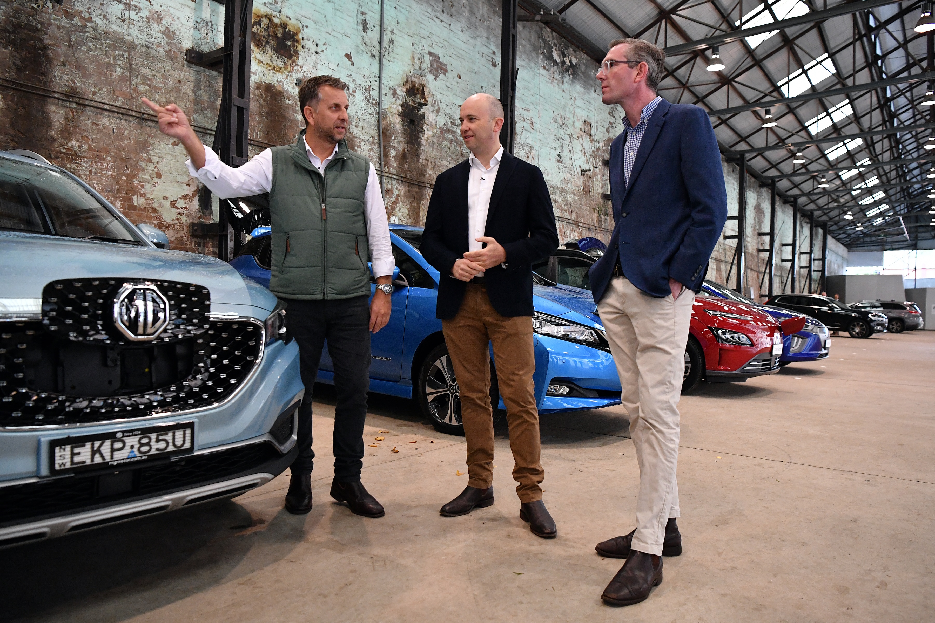 NSW Transport Minister Andrew Constance, Energy and Environment Minister Matt Kean an Treasurer Dominic Perrottet inspect electric cars in Sydney on Sunday.
