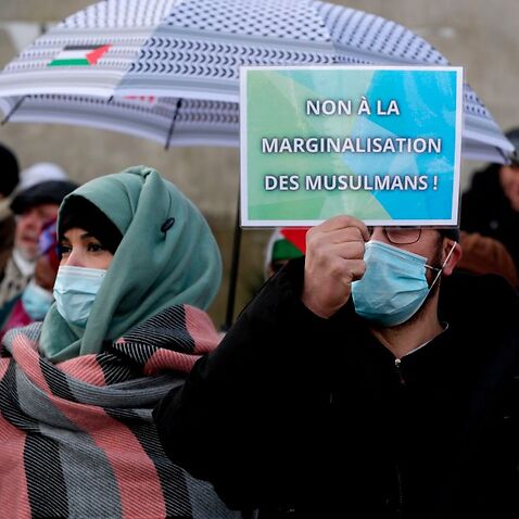 Ein Mann hält ein Plakat zur Unterstützung der muslimischen Gemeinschaft Frankreichs während eines Protestes gegen das Gesetz gegen den Separatismus am 14. Februar 2021 in Paris 