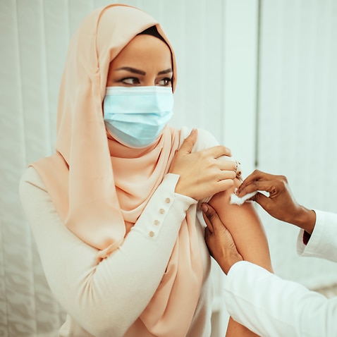 Muslim patient is taking a vaccine from a doctor