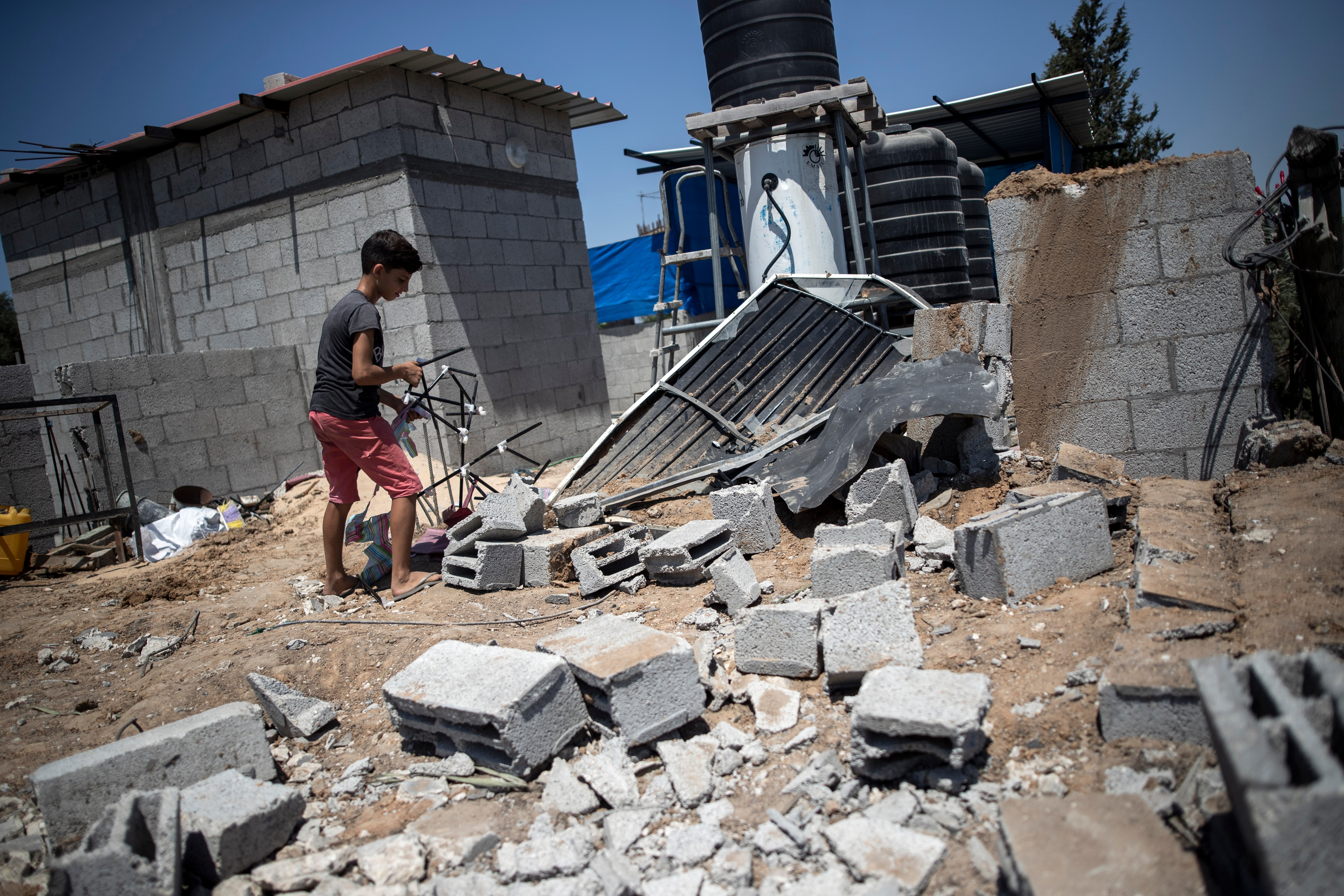 A Palestinian boy inspects the damage in his family home following Israeli airstrikes in Buriej refugee camp, central Gaza Strip.